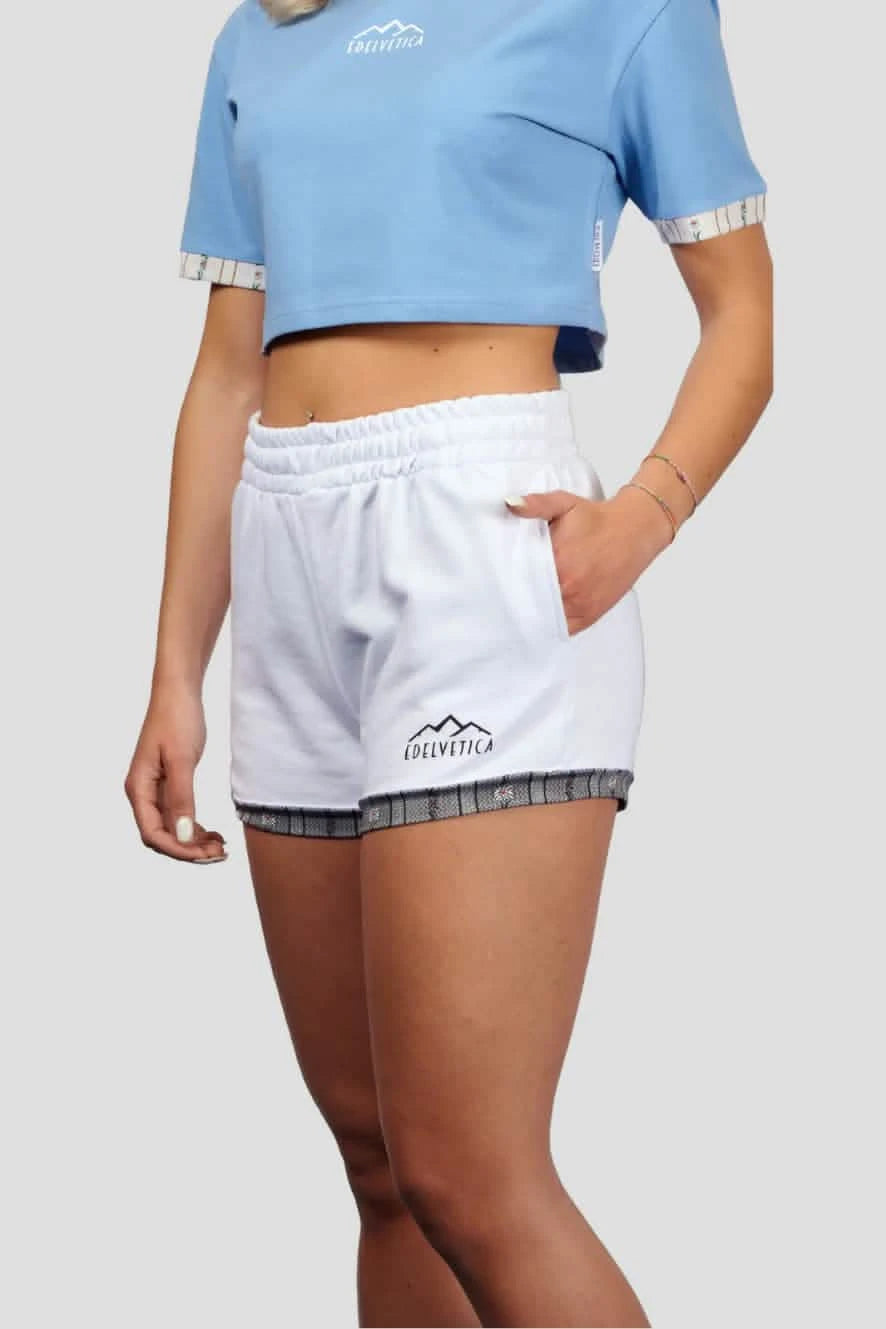 Damen Shorts von Edelvetica mit Edelweiss-Abschluss und Logo, eine modische und praktische Wahl für Freizeitaktivitäten. Diese Shorts zeichnen sich durch ein charakteristisches Edelweiss-Muster am Abschluss und das Edelvetica-Logo aus, was einen Hauch von alpiner Eleganz und Markenidentität verleiht. Ideal für Frauen, die lässige, aber stilvolle Kleidung schätzen.