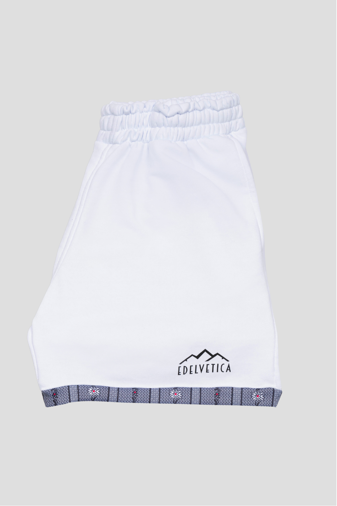 Herren Shorts von Edelvetica mit Edelweiss-Abschluss und Logo, eine modische und praktische Wahl für Freizeitaktivitäten. Diese Shorts zeichnen sich durch ein charakteristisches Edelweiss-Muster am Abschluss und das Edelvetica-Logo aus, was einen Hauch von alpiner Eleganz und Markenidentität verleiht. Ideal für Herren, die lässige, aber stilvolle Kleidung schätzen.