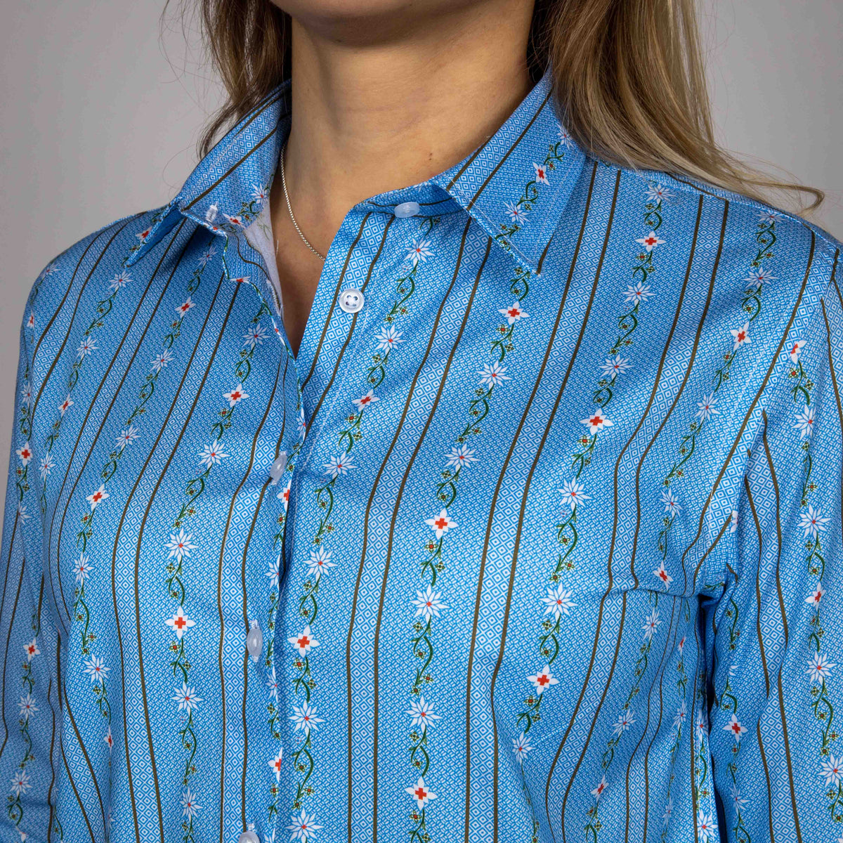 Damen Edelweiss Bluse von Edelvetica, gekennzeichnet durch ein traditionelles und zugleich modernes Design. Diese Bluse ist mit einem charakteristischen Edelweiss-Muster verziert und bietet eine perfekte Mischung aus Schweizer Tradition und zeitgemäßer Eleganz. Ideal für formelle und informelle Anlässe, bei denen stilvolle Kleidung gefragt ist.