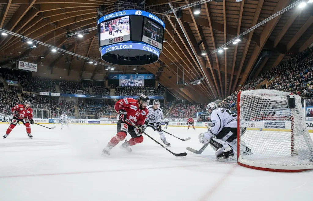 Eishockeyspieler im Angriff beim Spengler Cup Davos, voller Zuschauerrang in der Vaillant Arena mit intensiver Spielszene