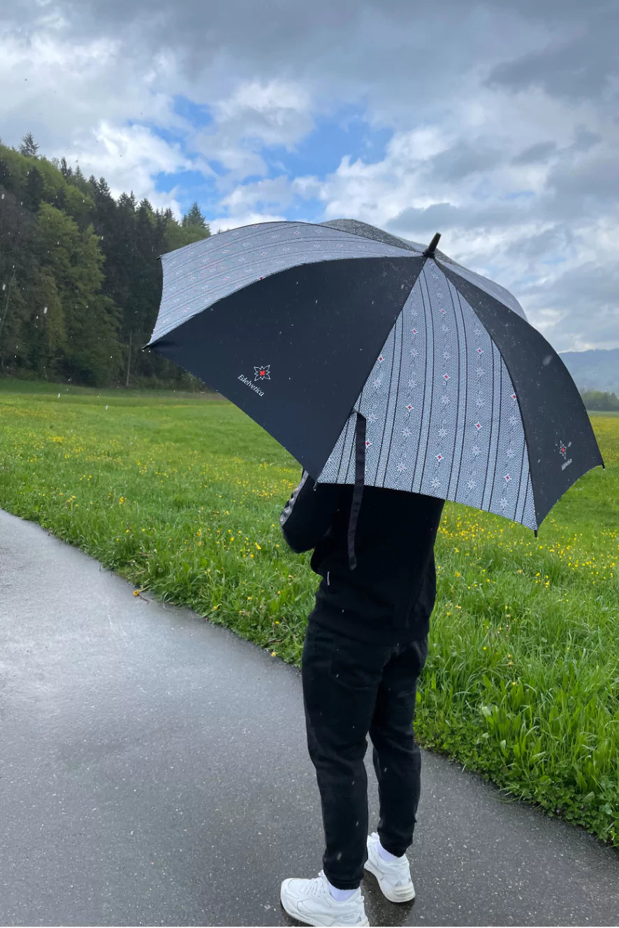 Edelvetica Edelweiss Regenschirm, ein eleganter und praktischer Begleiter für regnerische Tage. Der Schirm zeichnet sich durch sein auffälliges Edelweiss-Design aus, das einen Hauch von alpiner Eleganz vermittelt. Er ist perfekt für diejenigen, die auch bei schlechtem Wetter stilvoll und geschützt bleiben möchten.